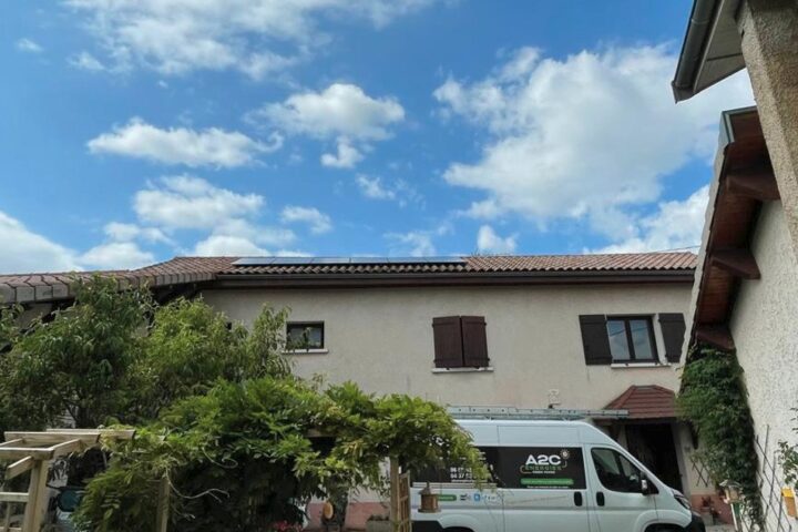 Installation photovoltaïque sur un toit, camion A2C Énergies devant la maison.